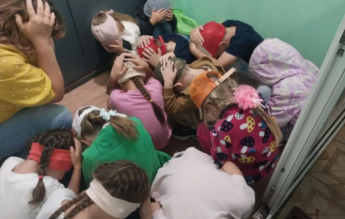 Exerciții cu copii culcați la podea și arme îndreptate spre ei, în grădinițele din Rusia