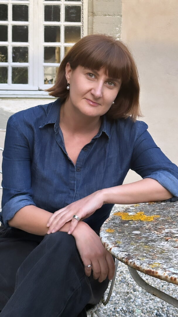 Femeie brunet roșcată care se sprijină de o masă de piatră